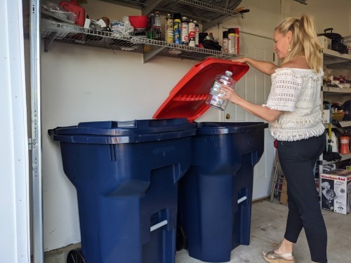 woman throwing plastic bottle in recycling trash can